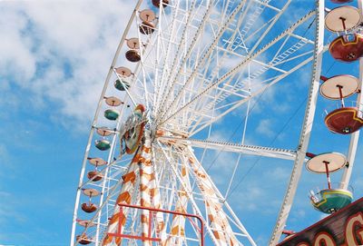 Low angle view of ferris wheel against blue sky