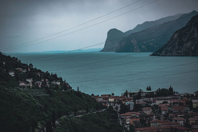 Scenic view of town by mountain against sky