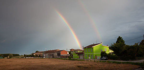 Scenic view of rainbow over buildings against sky