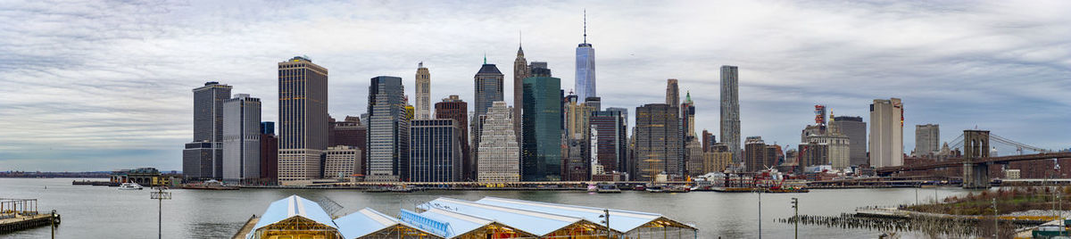 Panoramic view of buildings against cloudy sky