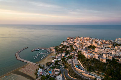 High angle view of buildings by sea against sky