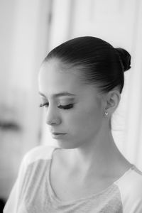 Close-up of young woman wearing false eyelash at home