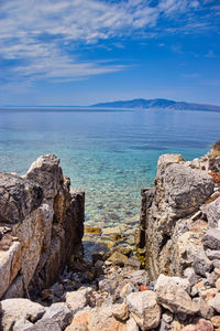 Rocks by sea against sky