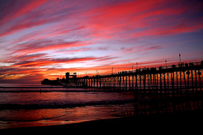 The universe paints a different portrait every evening. firey sky around the pier at sunset.