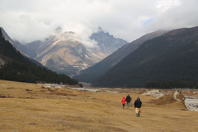 People in mountains against sky