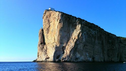 Low angle view of sea against clear blue sky