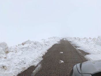 Road amidst snow against clear sky