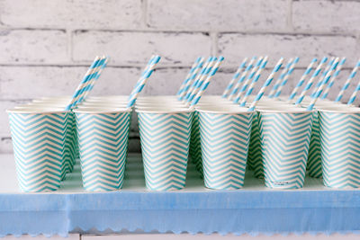 Disposable cups with straws on table