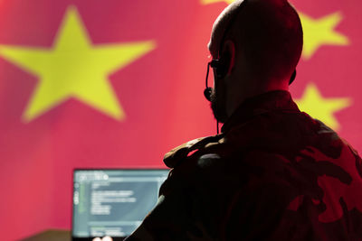 Rear view of man standing against wall