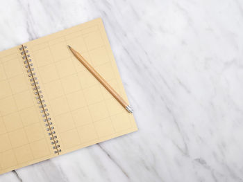 High angle view of book and pencil on table