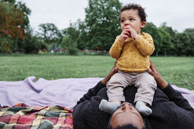 Father relaxing with son at park