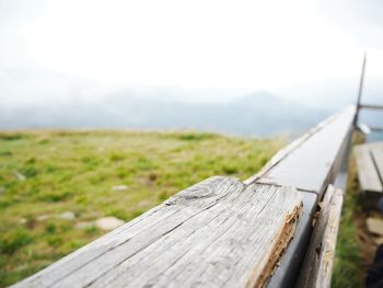 Close-up of wooden fence on field against sky