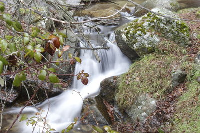 High angle view of stream flowing amidst rocks