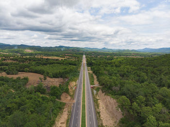 Panoramic shot of road amidst trees against sky