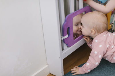 Toddler girl kissing mirror