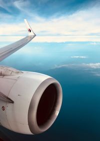 Airplane flying over sea against sky