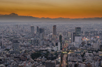 Aerial view of buildings in city during sunset