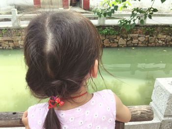 Rear view of girl looking at water