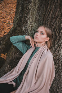 Portrait of a smiling young woman with tree trunk