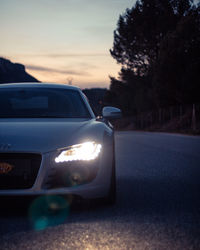 Close-up of car on road at sunset