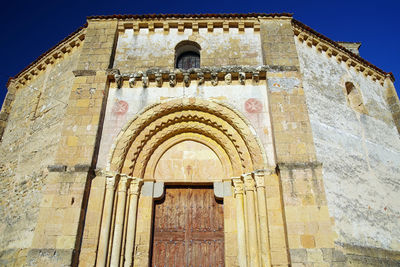 Low angle view of cross on building against sky