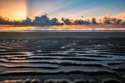 Scenic view of beach against sky during sunset