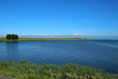 Scenic view of lake against blue sky