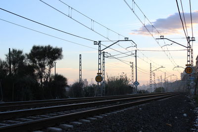 Railroad tracks against sky during sunset