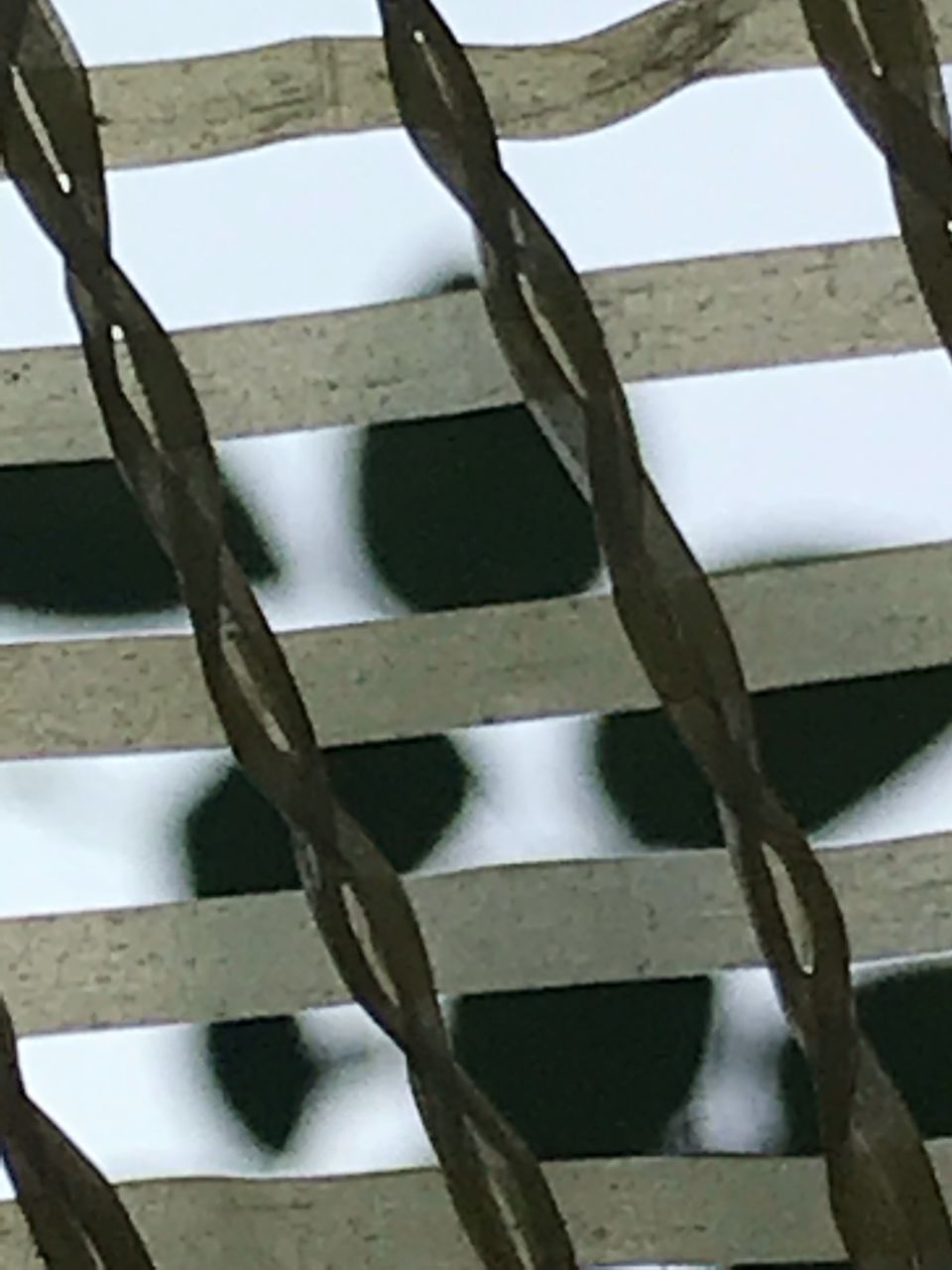 CLOSE-UP OF METAL FENCE AGAINST WOODEN GATE