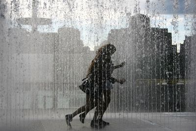 Shadow of man on wet window during rainy season