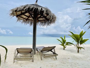 Chair on beach against sky