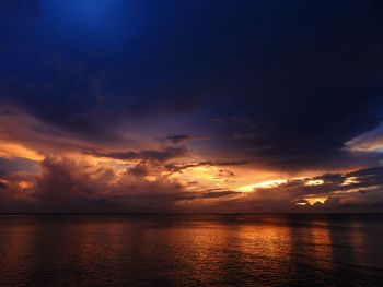 Scenic view of sea against dramatic sky during sunset