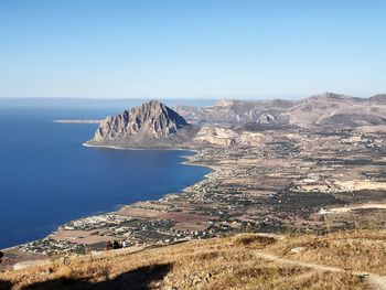 Scenic view of sea and mountains against clear blue sky