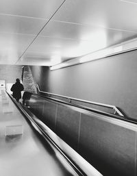 Woman standing on escalator