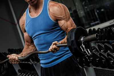 Midsection of man exercising in gym