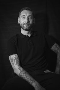 Portrait of smiling man sitting in the dark