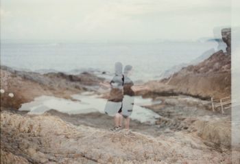 Double exposure of friends and rocky shore