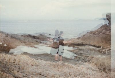 Woman standing by sea against sky