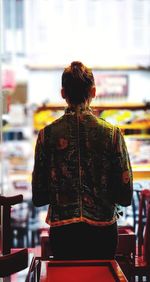 Rear view of woman standing at home