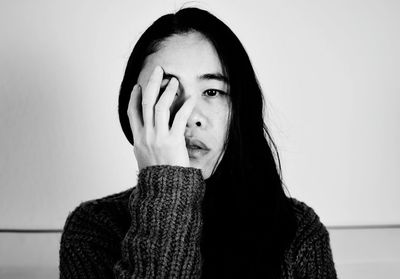 Portrait of young woman against wall