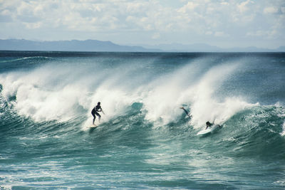 Man surfing in sea against sky