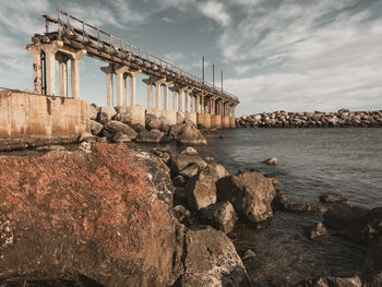 View of bridge over sea against cloudy sky