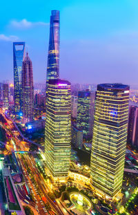 Illuminated buildings in city against sky at night