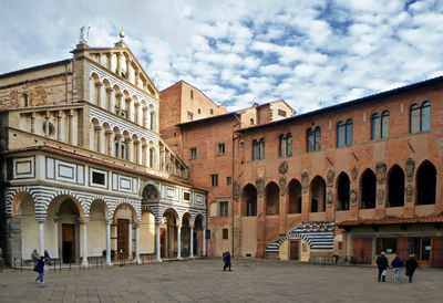 Tourists against cloudy sky