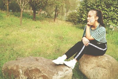 Young woman sitting on grass in park