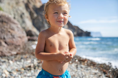 Portrait of shirtless man standing at beach