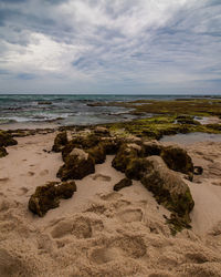 Rocks on beach against sky