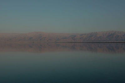 Scenic view of lake against clear blue sky