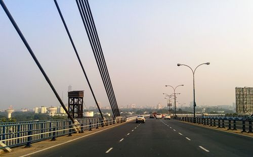 Vehicles on highway against clear sky