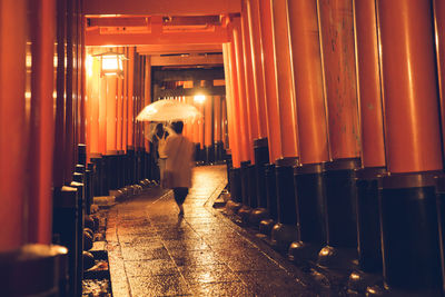 Rear view of man walking in illuminated temple